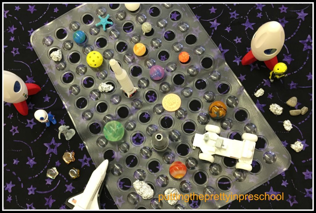 Space themed table diorama with objects to rearrange.