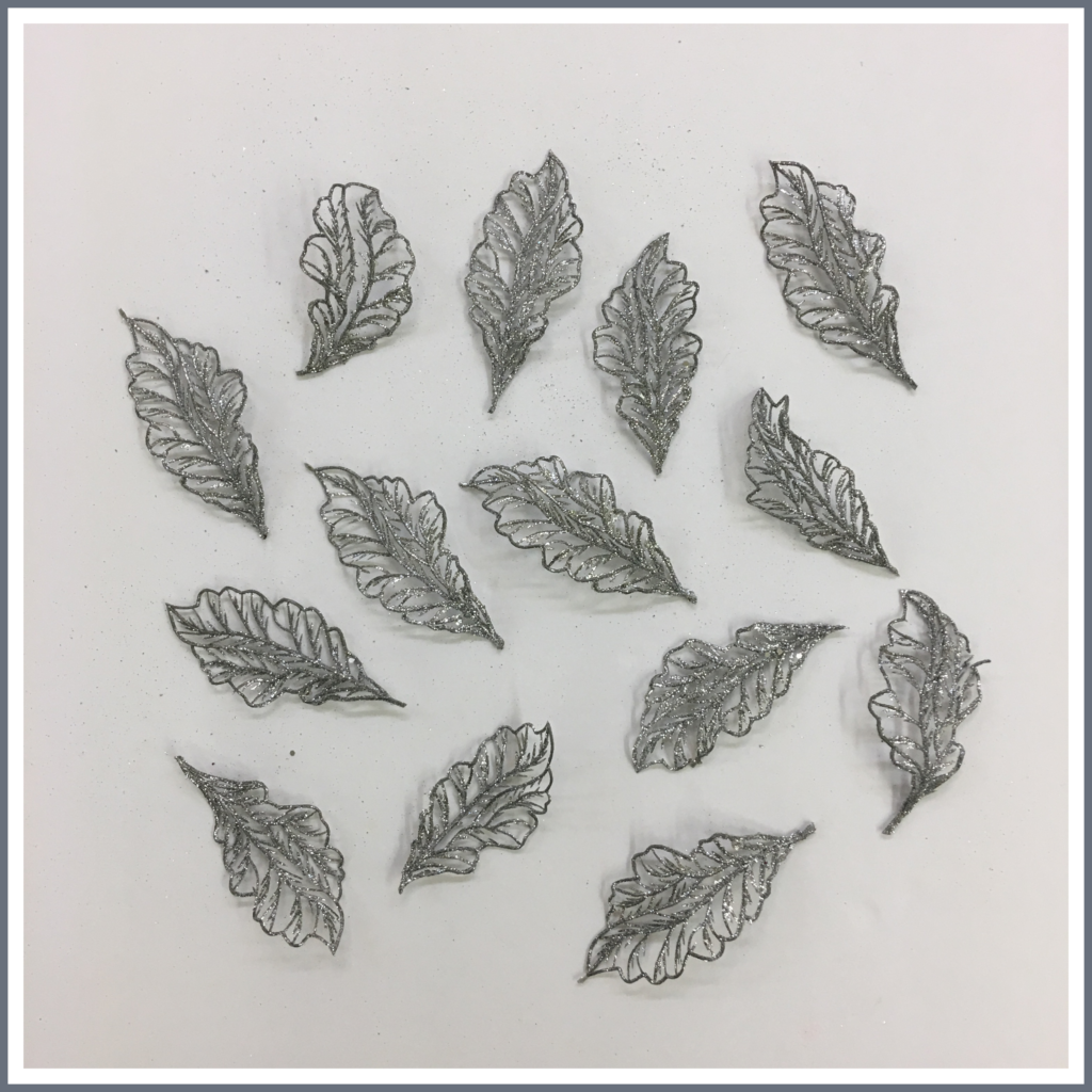 Silver metallic leaves cut from a stem.