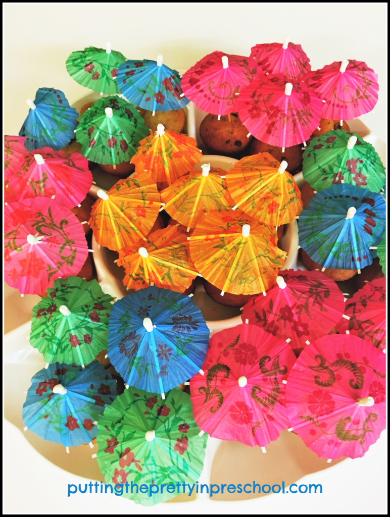 Muffins decorated with parasols for a Hawaiian party snack.