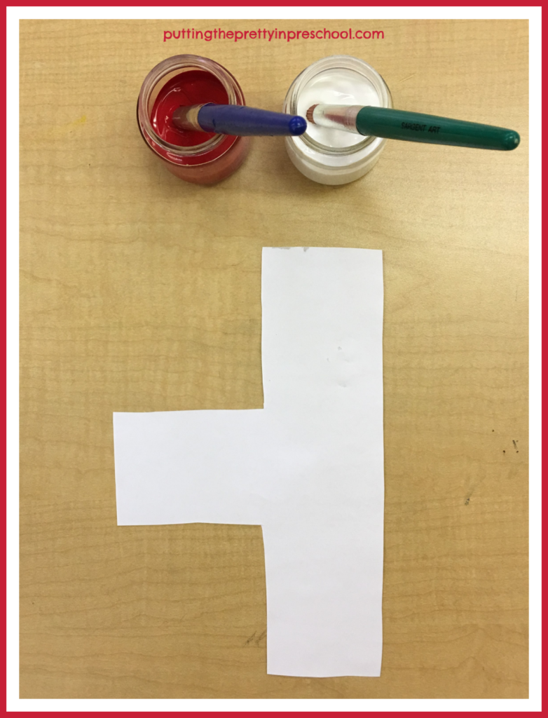 Color mixing paint activity: red and white paint set up with an unusual paper shape.