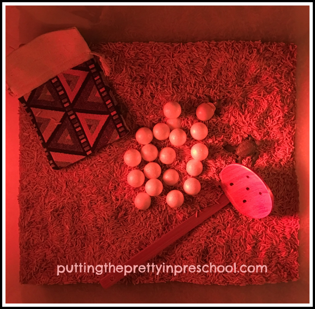 Sea turtle egg rescue rice sensory bin with a red light.