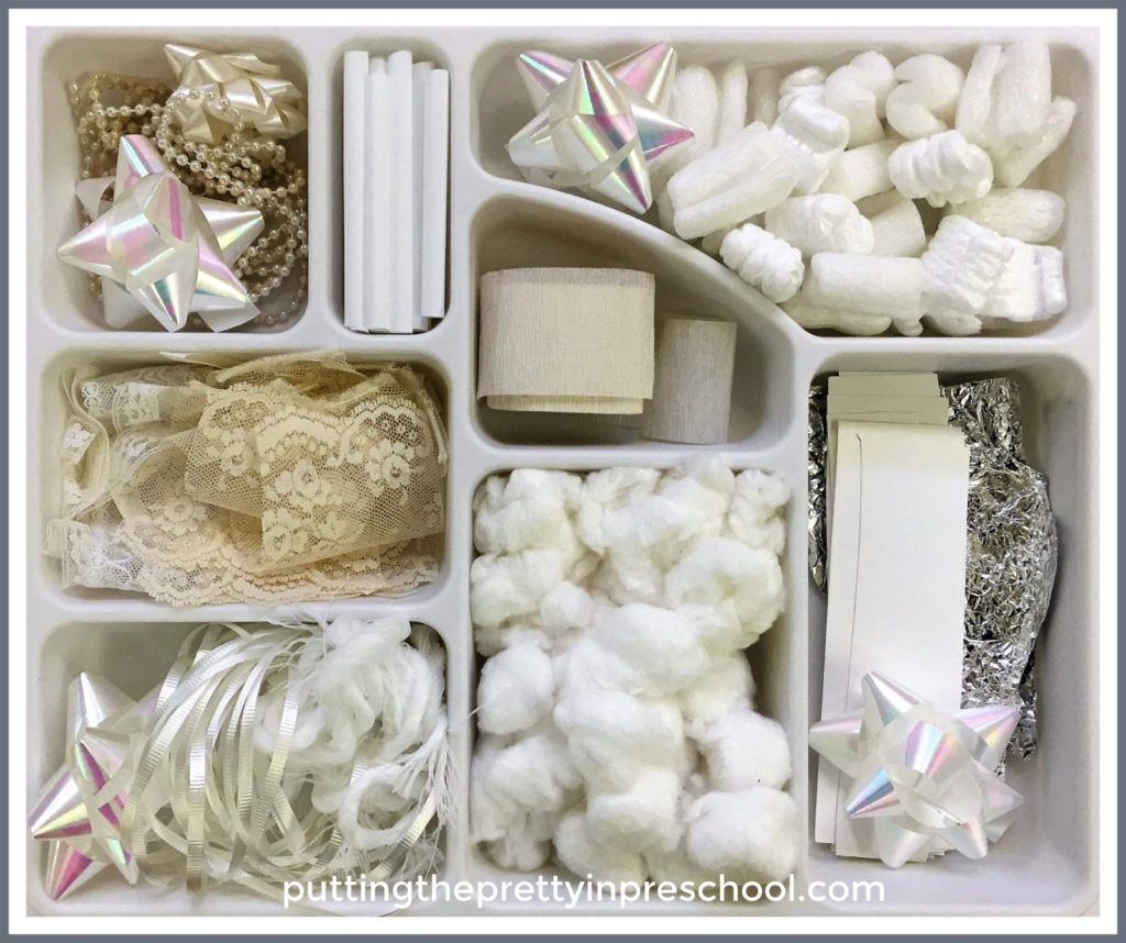 White and neutral craft supply tinker tray. Scissor skill activity to create fake snow and bits and pieces for collage and sensory activities.