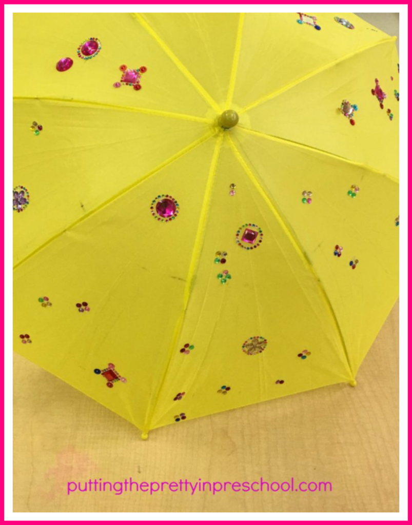 Umbrella decorating. Sticker gems and rhinestones adorn the umbrella. This project is inspired by an activity at a Chinese Valentine's Day celebration.