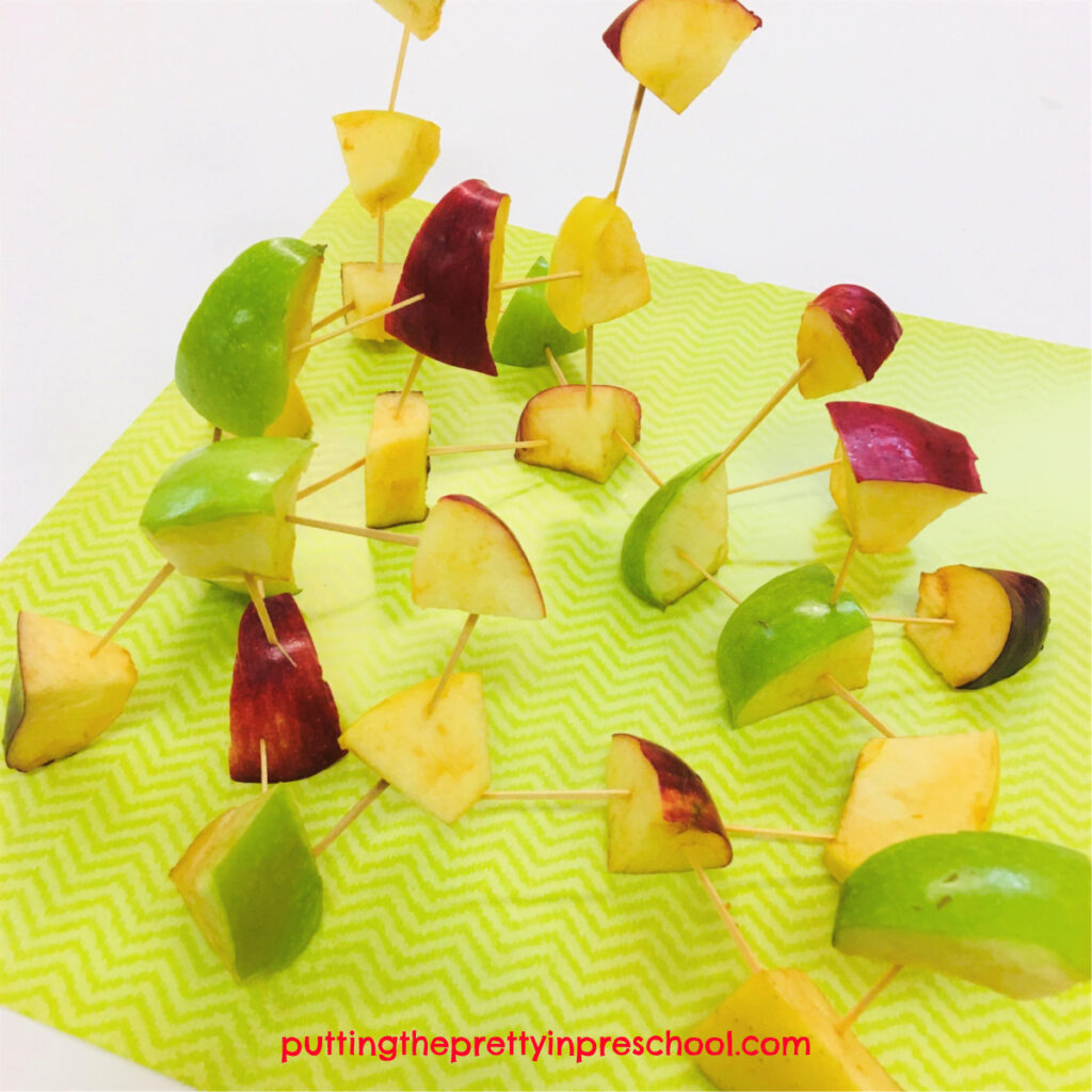 Apple chunk and toothpick sculpture. Yello, green, and red apples are used to make a colorful structure.