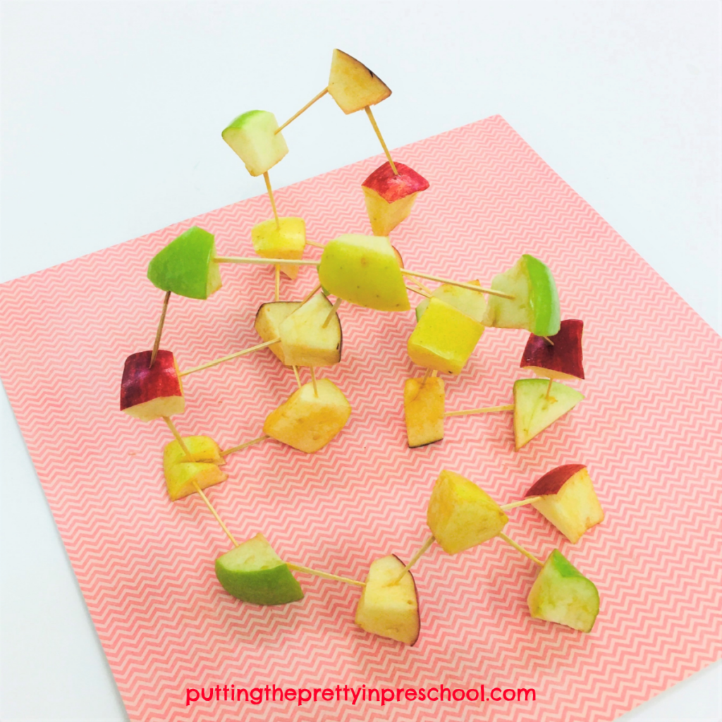 Apple chunk and toothpick sculpture. Yello, green, and red apples are used to make a colorful structure.