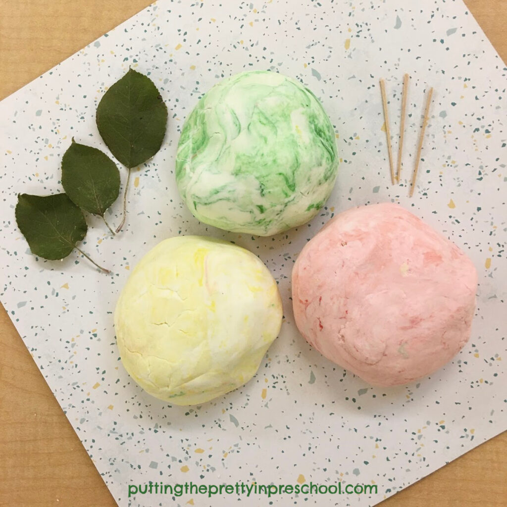 Invitation to create apples with scented, two-ingredient playdough, toothpicks, and apple leaves.