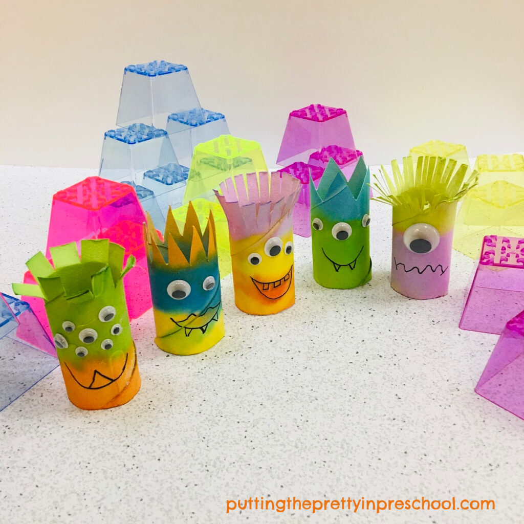 Toilet paper roll monsters with stacking blocks ready for imaginative play.