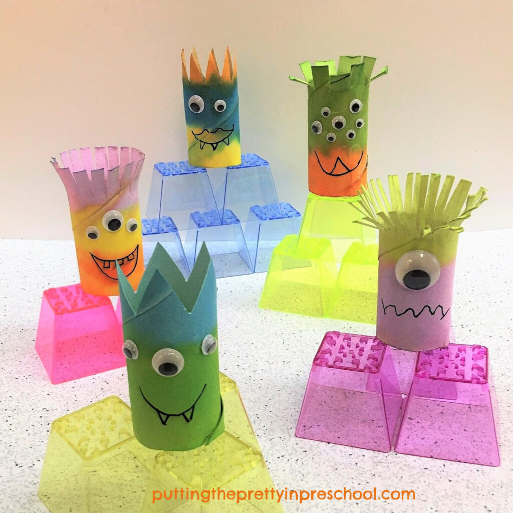 Toilet paper roll monsters on display on stacking blocks.