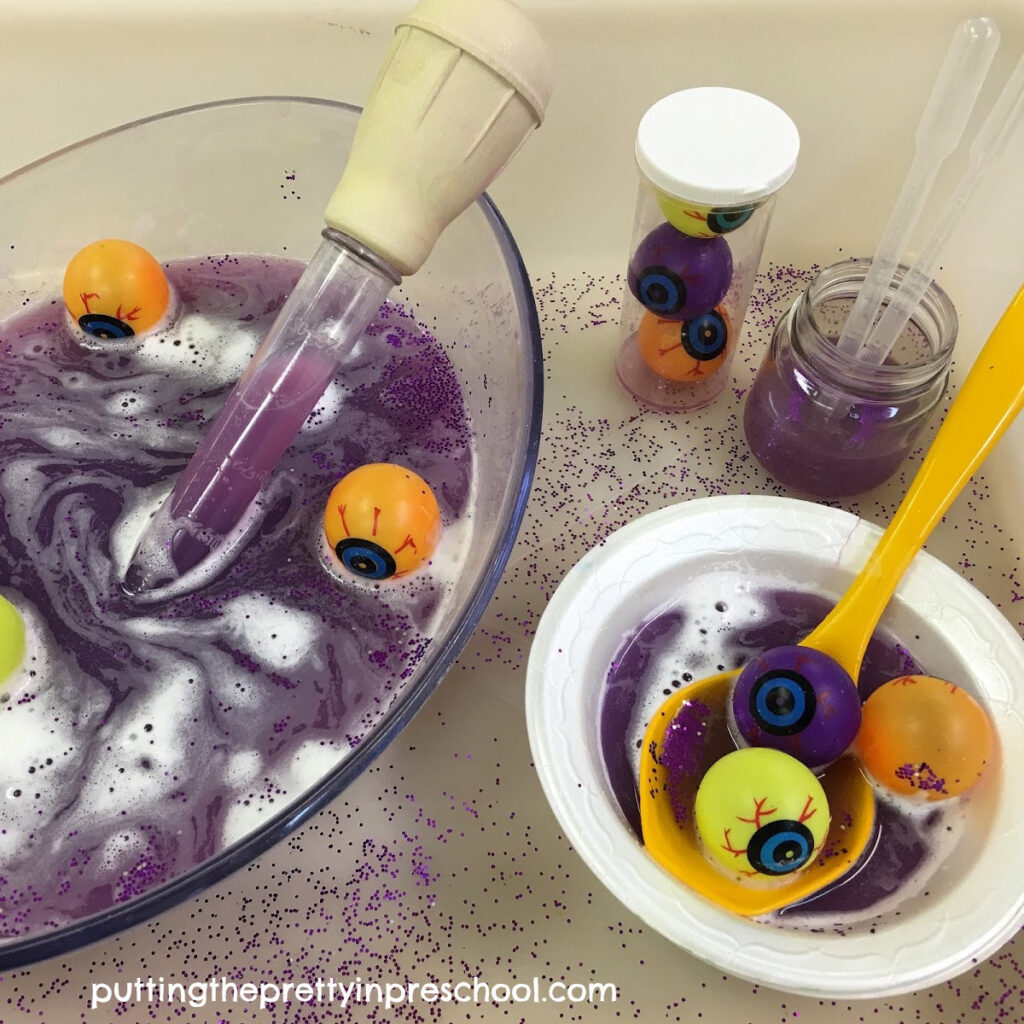 Eyeball soup water play with eyedroppers, a ladle, a baster, and pouring containers.