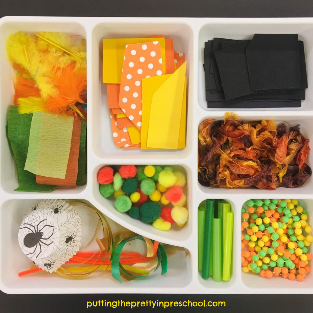 Scissor skills tray with yellow, orange, green, and black craft supplies. Invitation to cut materials for a pumpkin collage craft.