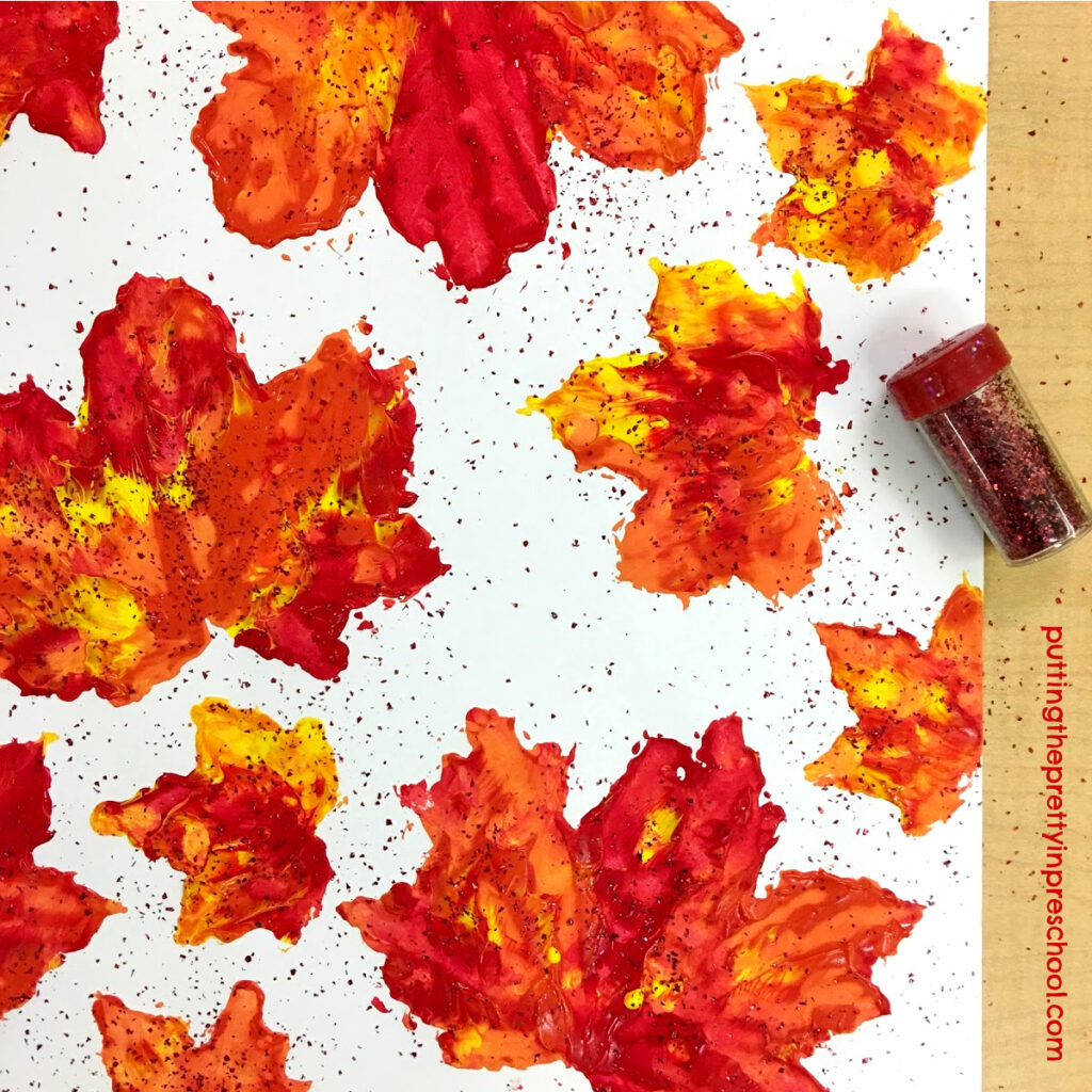Glitter added to tempera paint maple leaf prints.