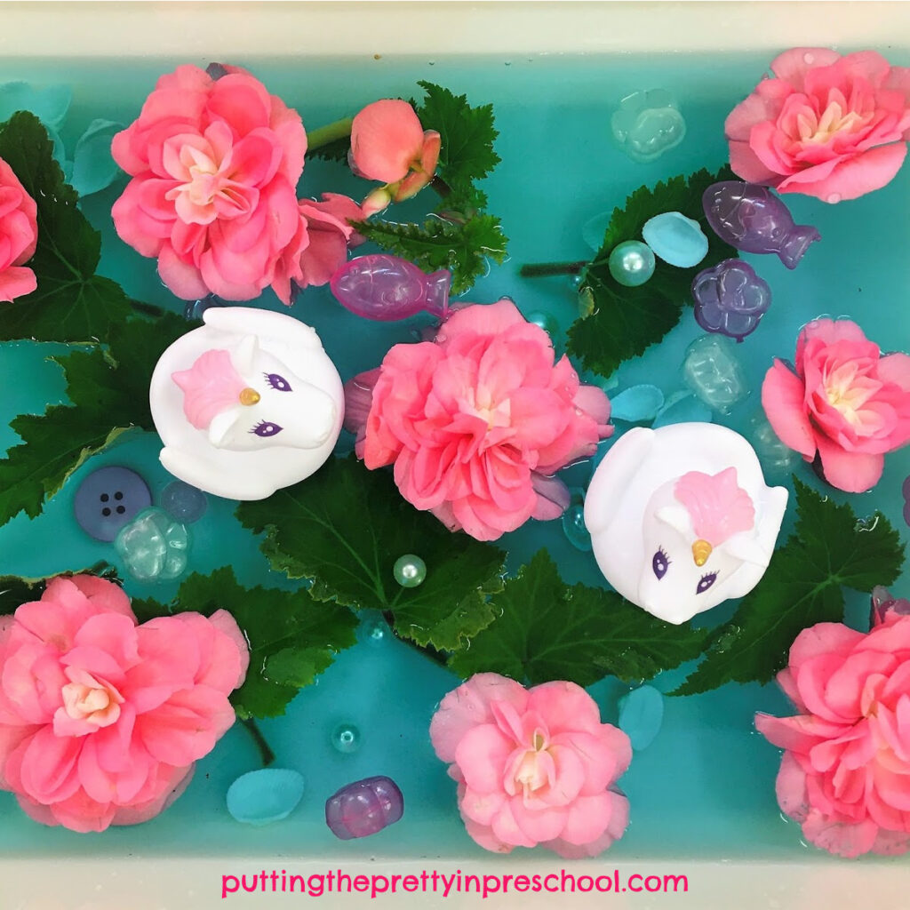 Unicorn and nonstop pink begonia sensory tub. Gem pearls, fish and flower ice cubes, shells, and buttons are part of the water tub.