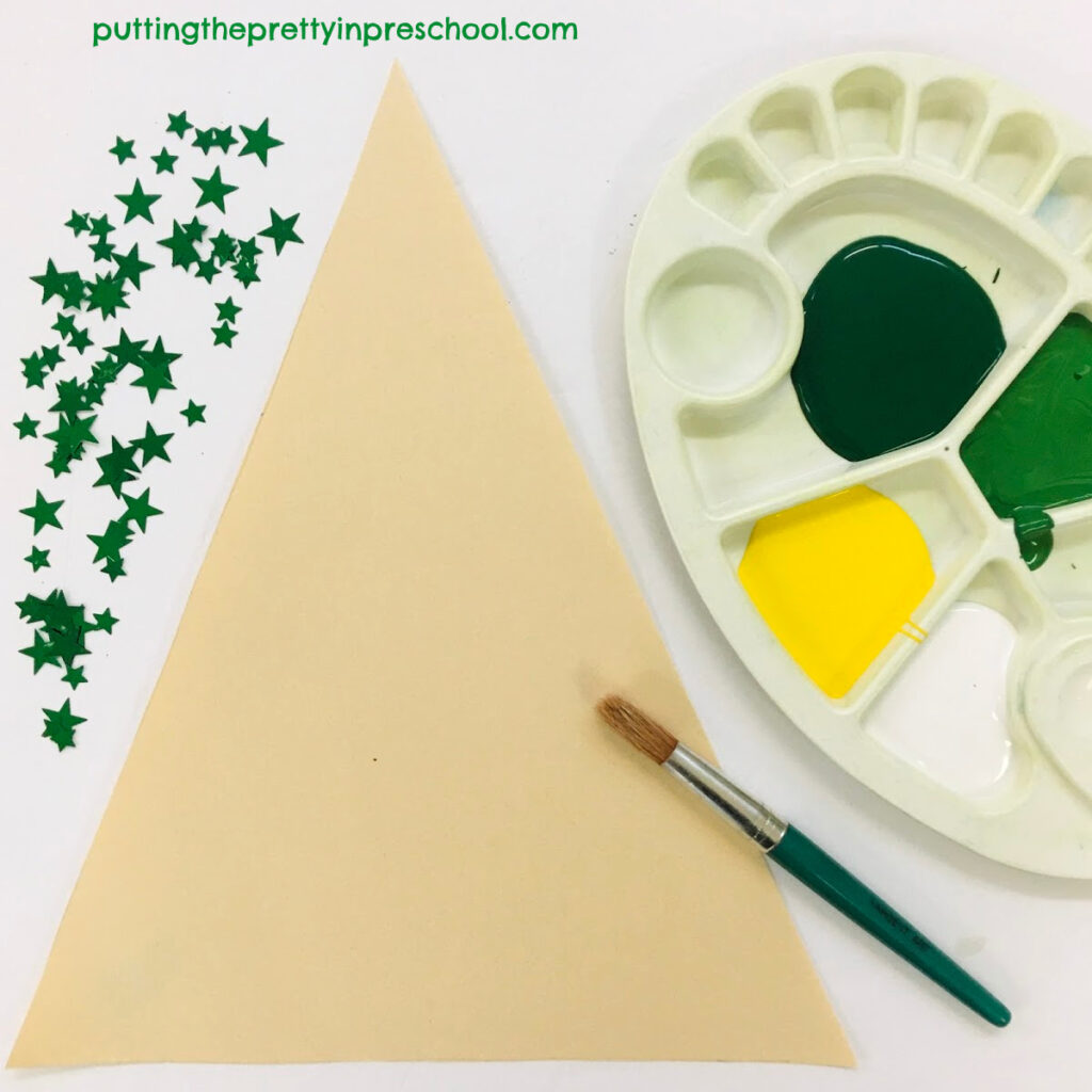 Christmas tree art set up with white, yellow, and green paint hues.