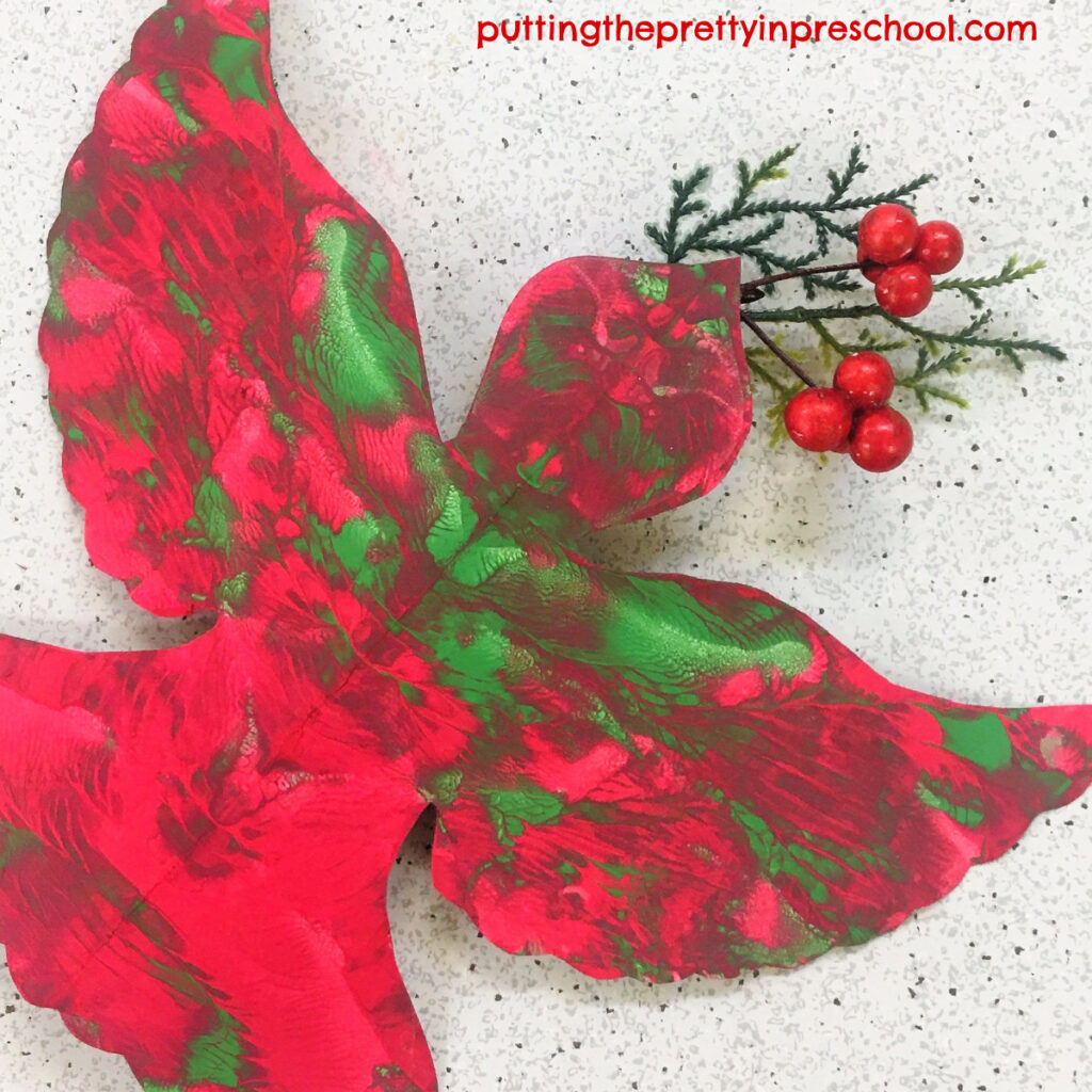 A sprig from a Christmas stem is the finishing touch for this squish painted red and green dove.