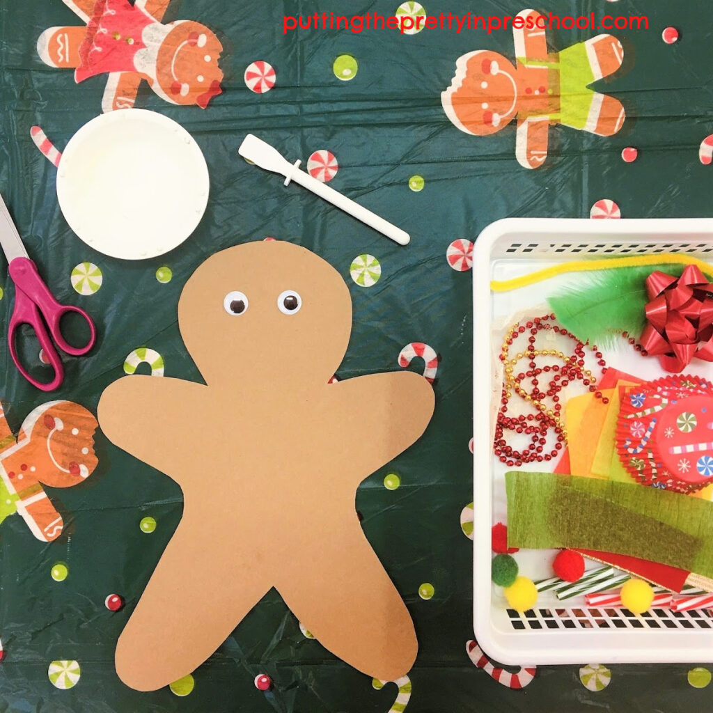 Invitation to cut and glue Christmas-themed craft supplies to decorate a kraft paper gingerbread man.