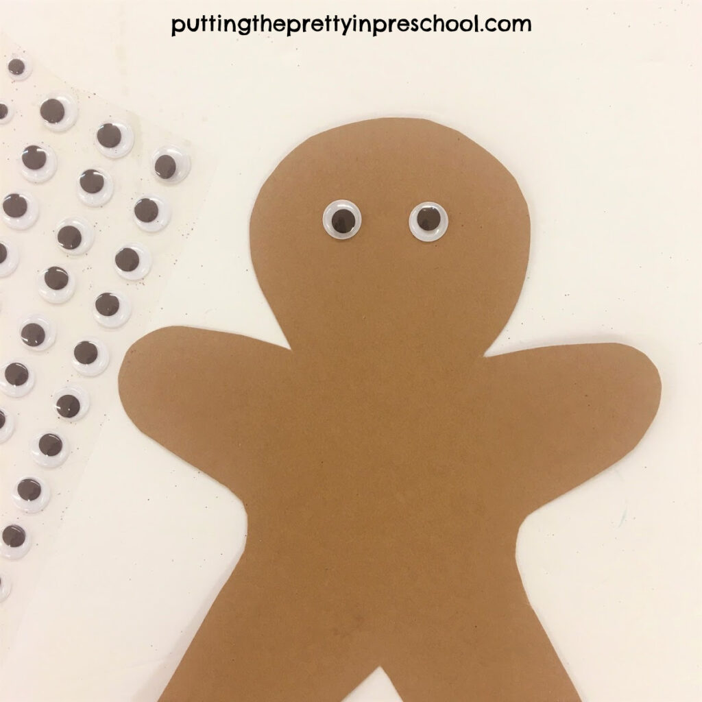 Adhesive wiggly eyes added to a kraft paper gingerbread man.