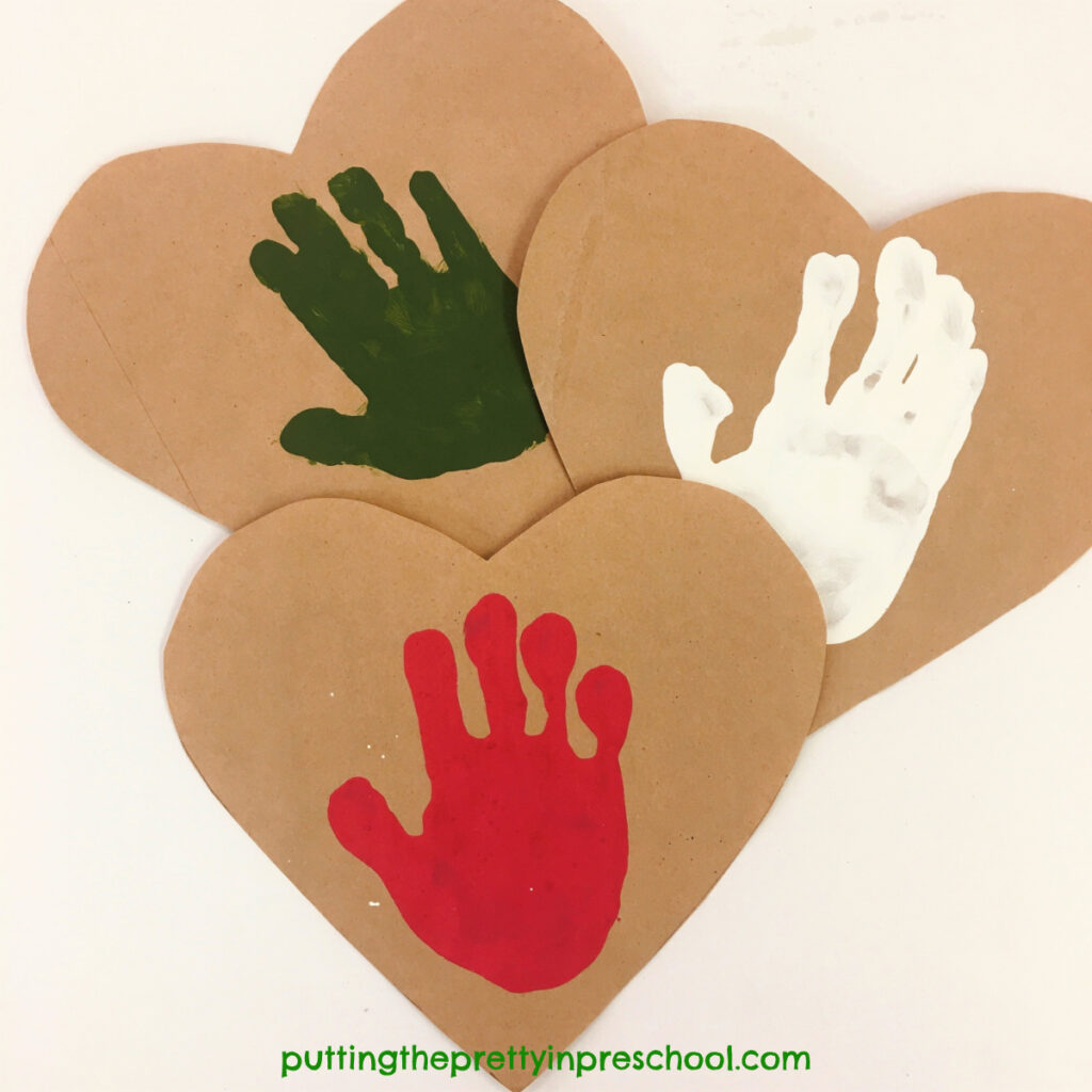 Paper bag hearts with red, green, and white handprints.