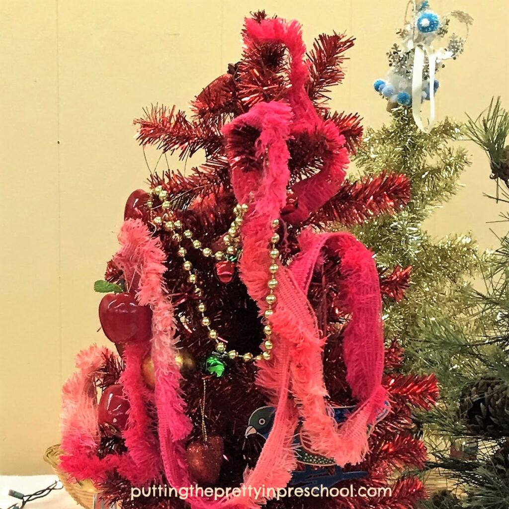 Red Christmas tree decorated with lots of garlands.