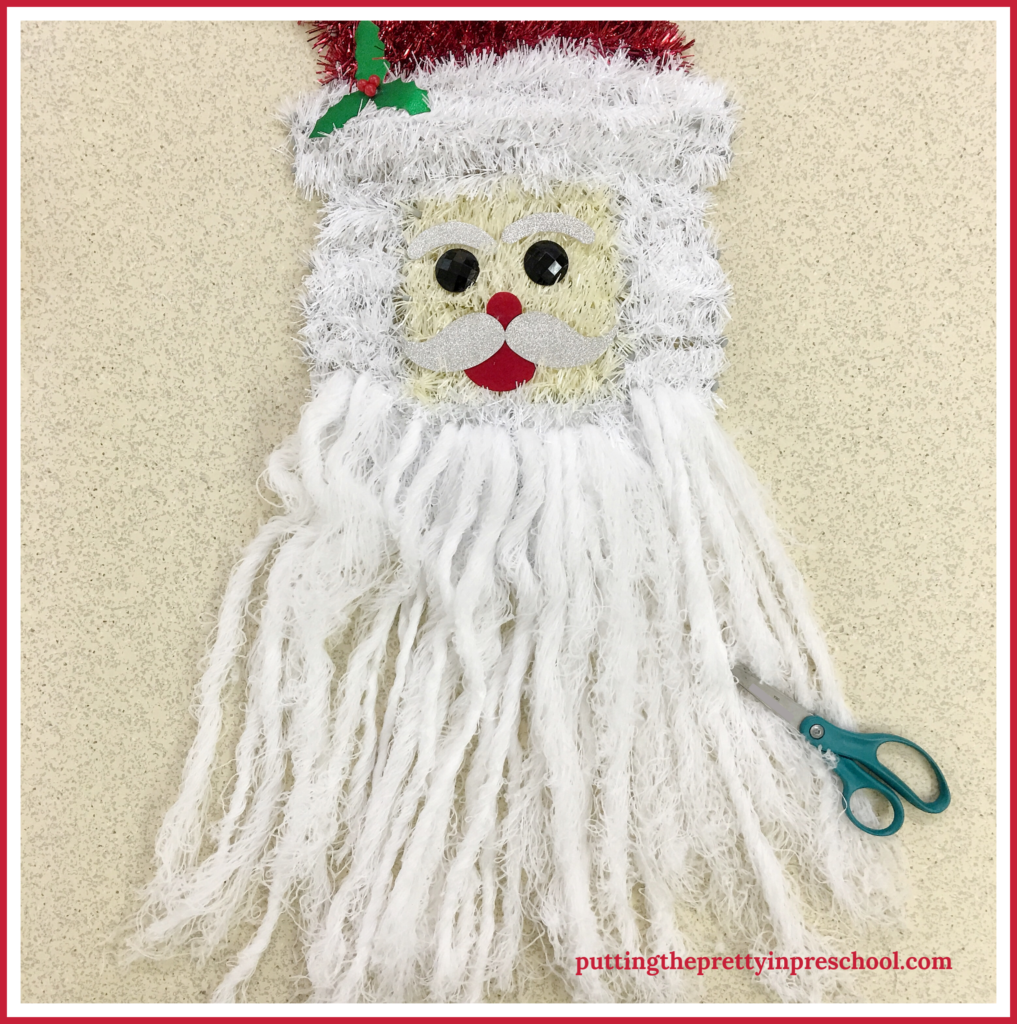 An invitation to trim Santa's beard with repurposed wall decor. A scissor skill activity for young children.