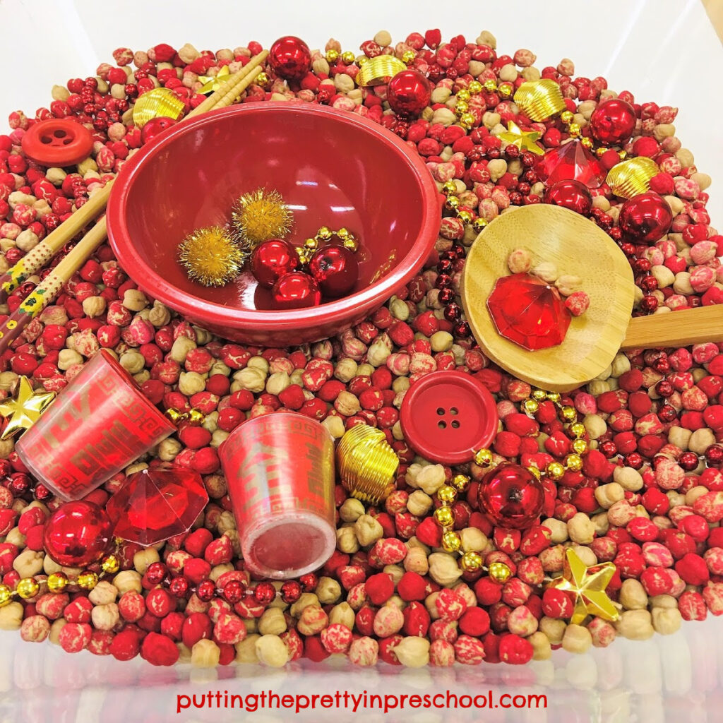 Red and gold accessories complement this chickpea-based Chinese New Year sensory tub.