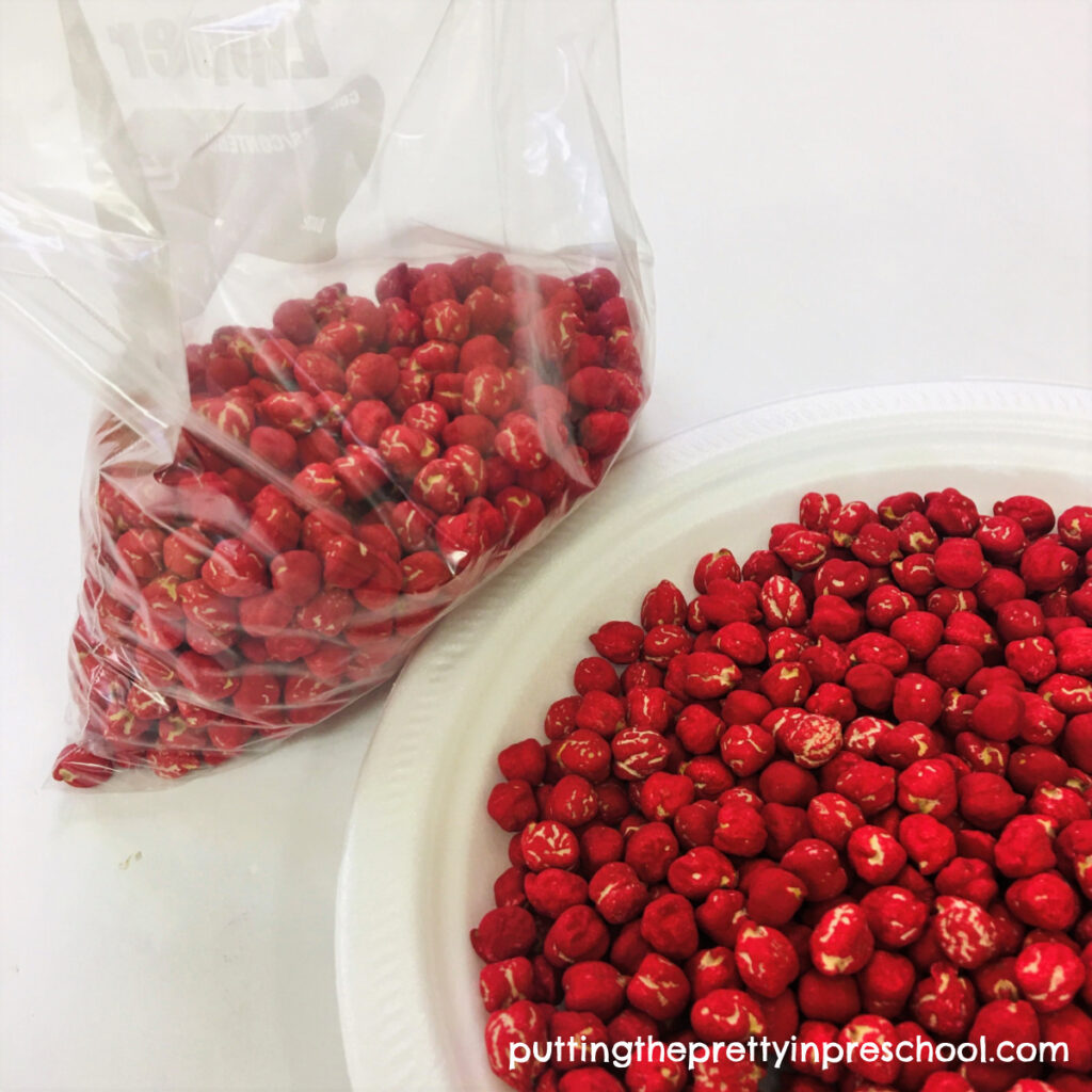 Chickpeas dyed with red acrylic paint for sensory play.