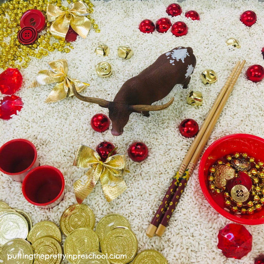 Chinese New Year "Year of The Ox" rice-based tray featuring a bull figurine and red and gold loose parts.