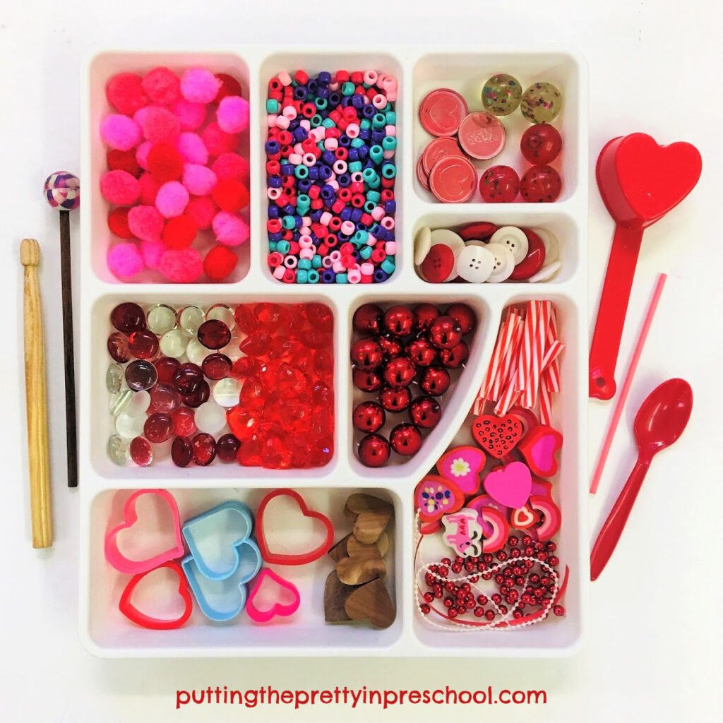 Loose parts to add to Valentine's Day containers to make shaker and drum musical instruments, and a variety of drumsticks.
