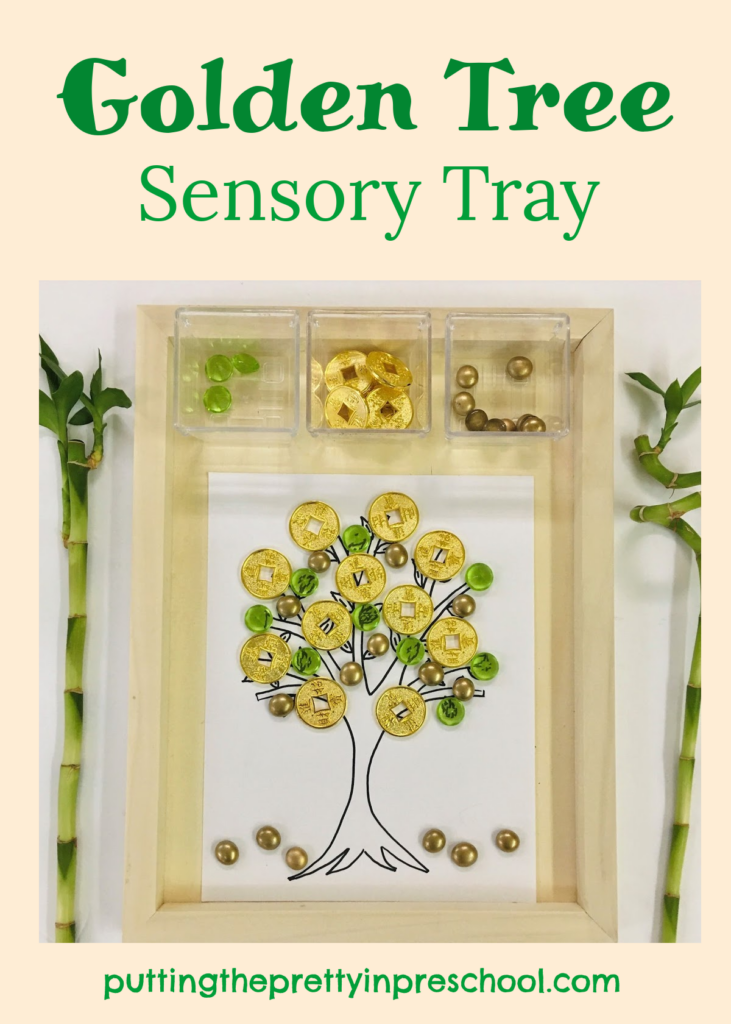Golden tree sensory tray with coins and green and gold loose parts.