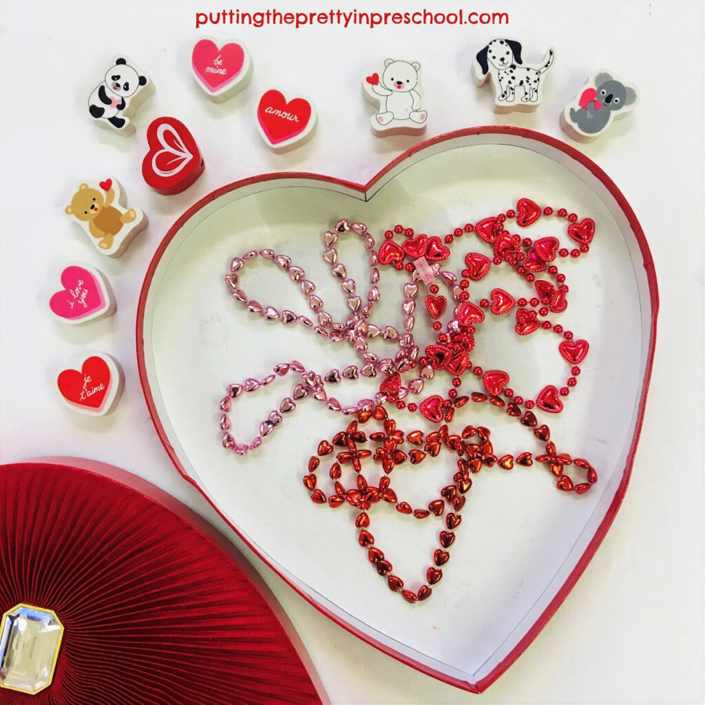 A heart-shaped empty chocolate box with necklaces or loose parts added makes an ocean drum.