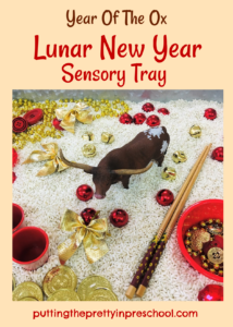 Year of the Ox Lunar New Year rice-based sensory tray with a bull figurine and red and gold loose parts.