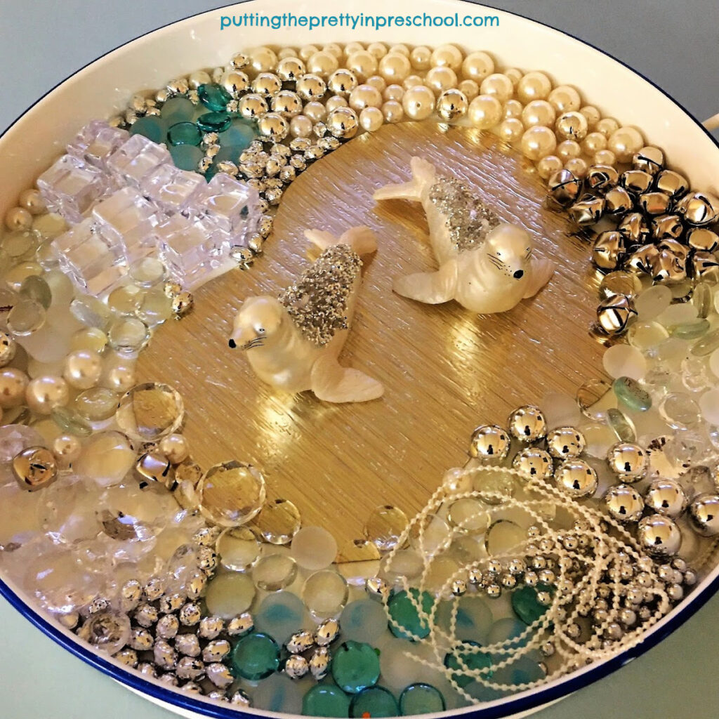Glittery seals take center stage in this aquatic polar animal sensory tray.