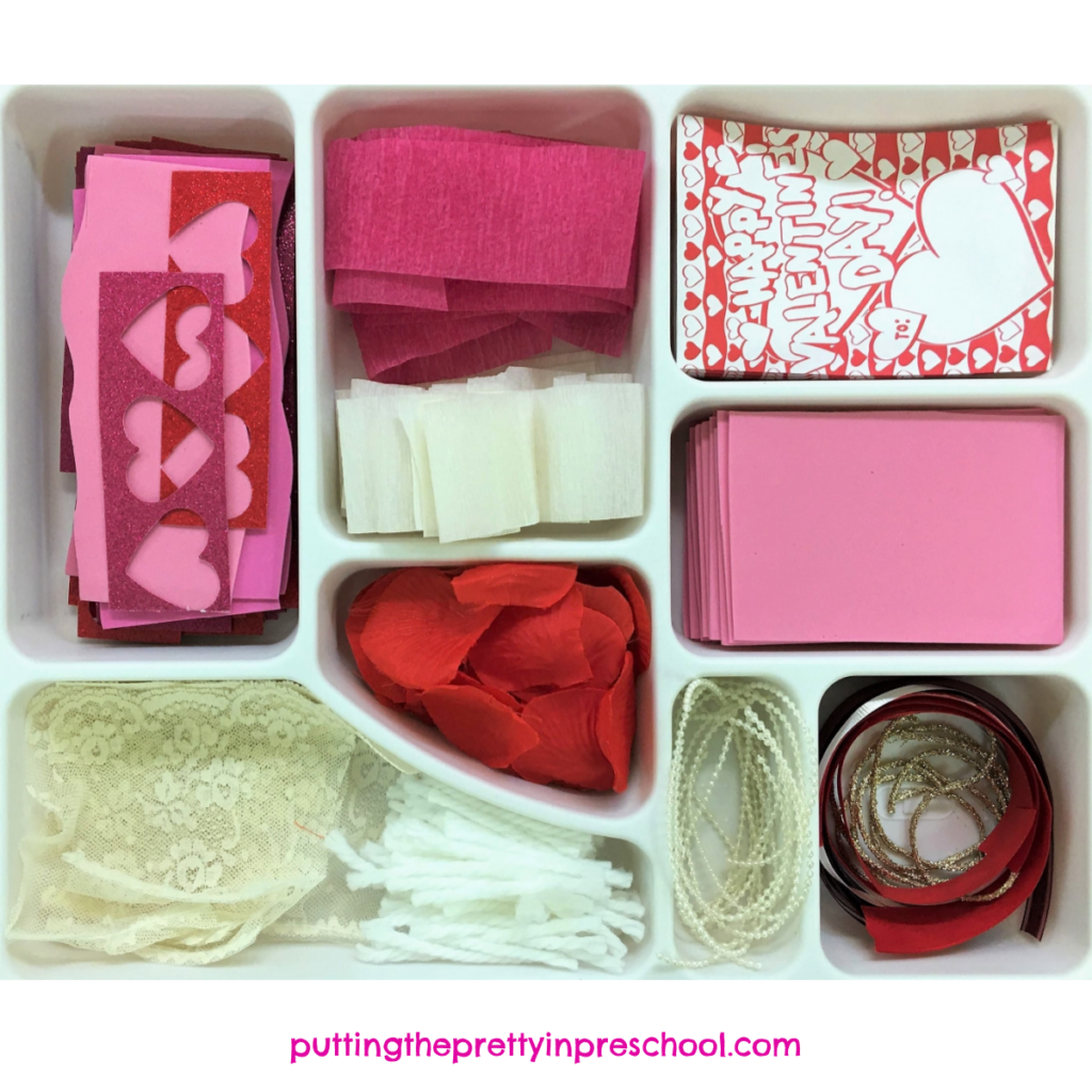 Red, pink, and white craft supply tray for heart collage projects.