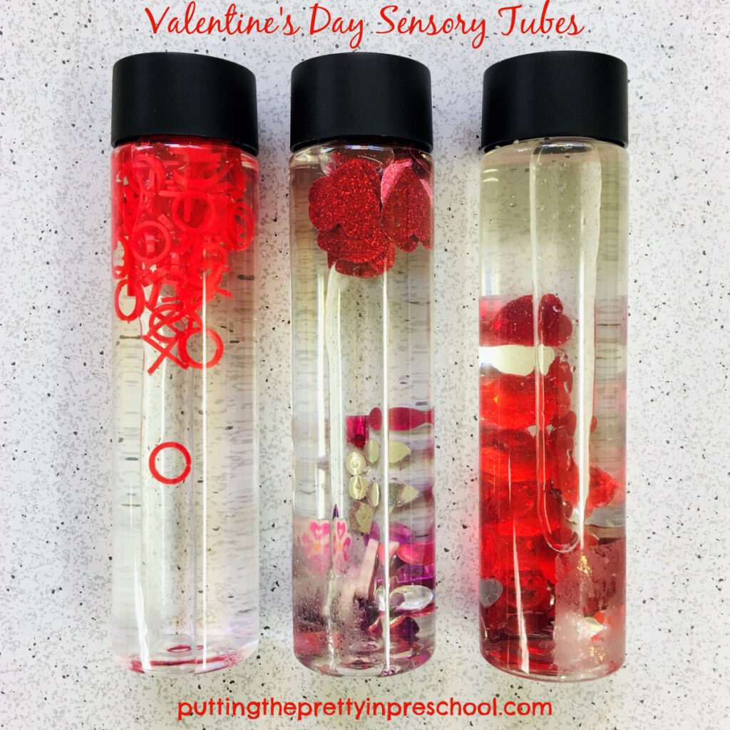 Valentine's Day sensory tubes with red, pink, and purple loose parts.