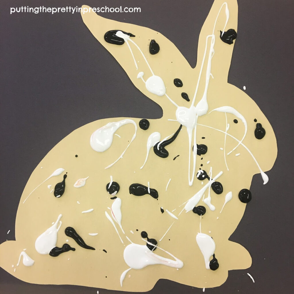 A spatter-painted paper bunny ready to be finished with a rolling pin painting technique.