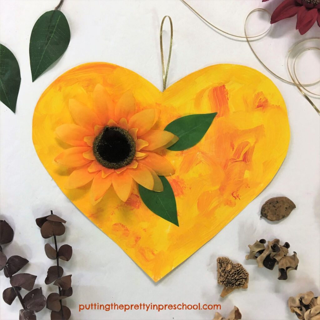 A painted heart embellished with a sunflower perfect for displaying in autumn.