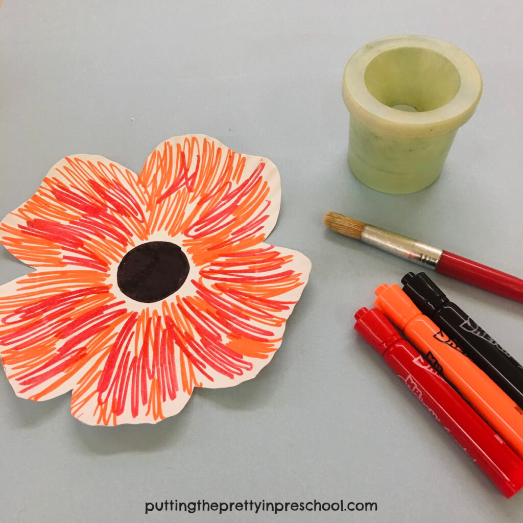 Supplies to make a paper plate poppy.
