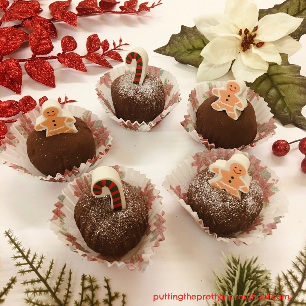 Holiday erasers and white glitter add a festive touch to this chocolate mint playdough activity.