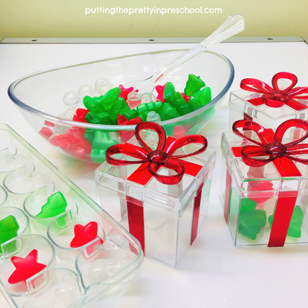 Clear gift boxes are the perfect containers for scooping reusable Christmas-themed ice cubes at the light table.