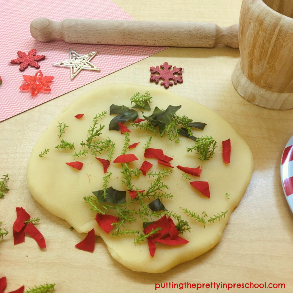 Lemon cypress scented holiday playdough invitation with cut silk poinsettia leaves and bracts.