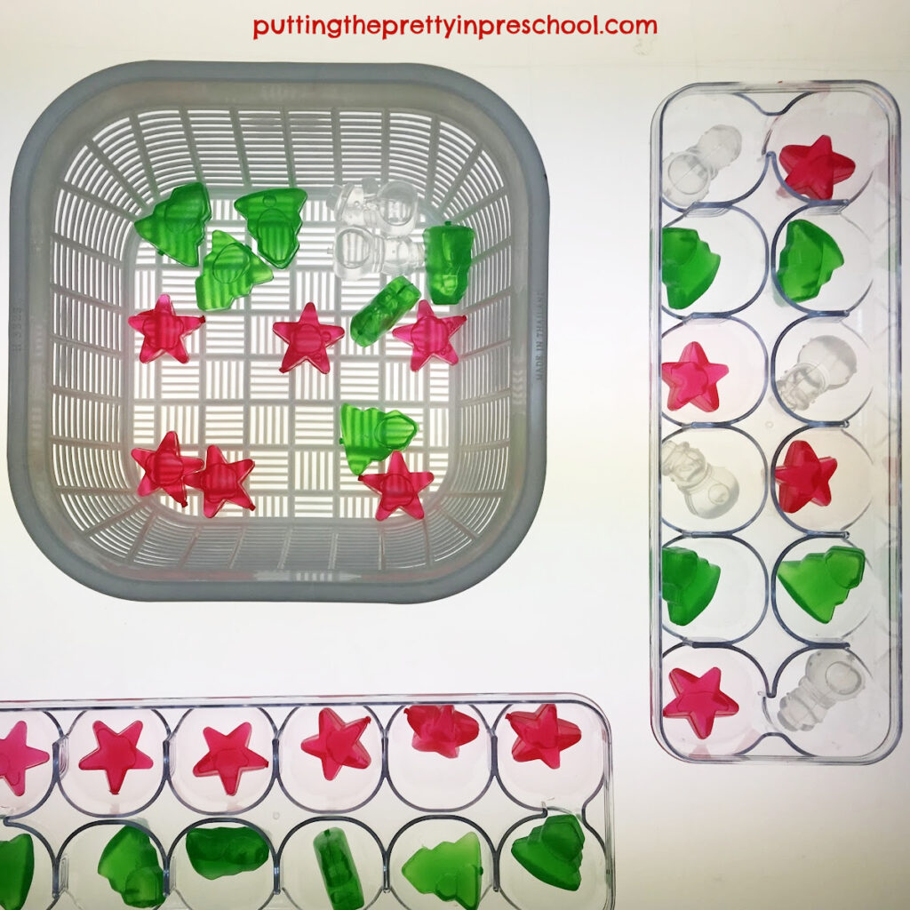Invitation for little learners to count and sort reusable Christmas-themed ice cubes at the light table.