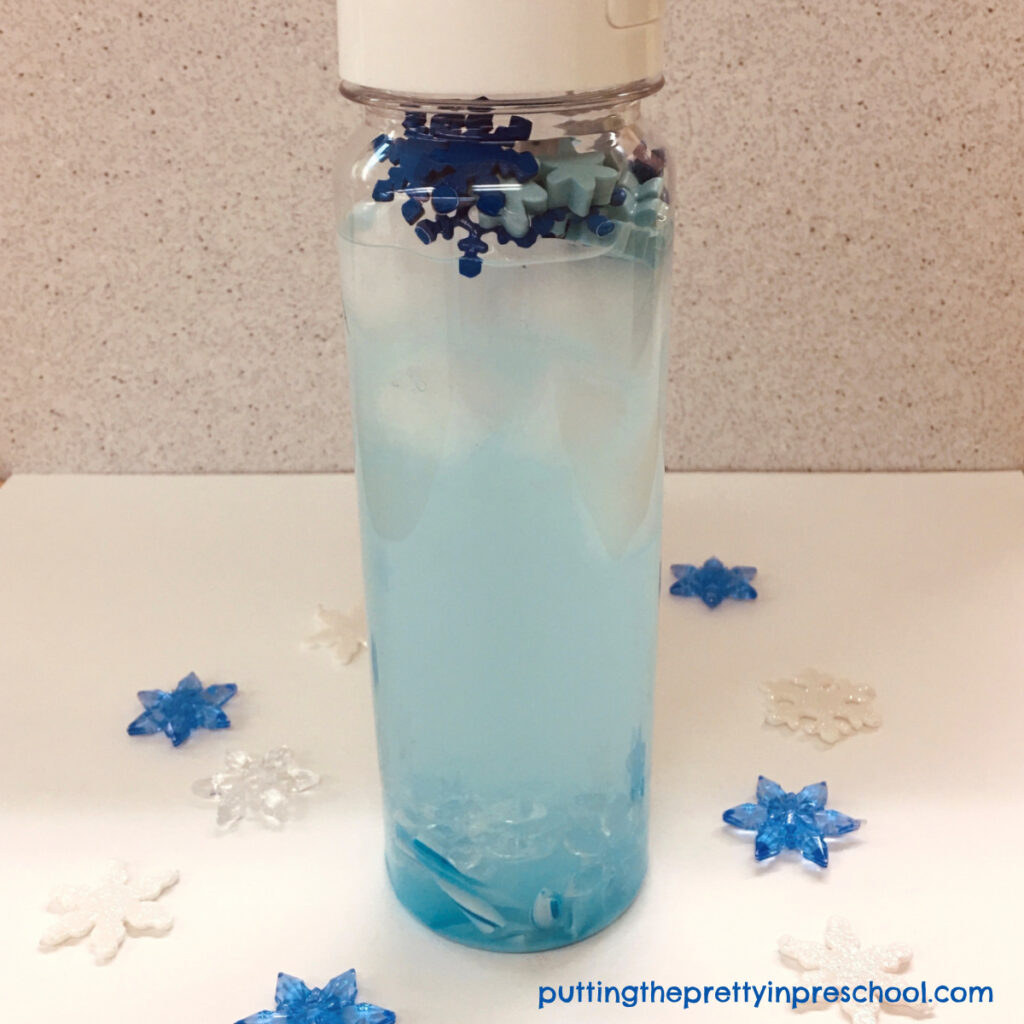 An icy blue candy cane winter sensory tube doubling as a float and sink experiment.