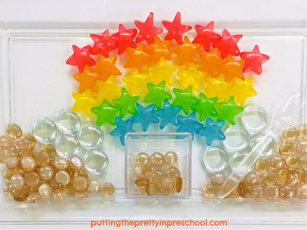 Colorful transparent reusable ice cubes are the "stars" of this cheery rainbow sensory tray designed for a light table.