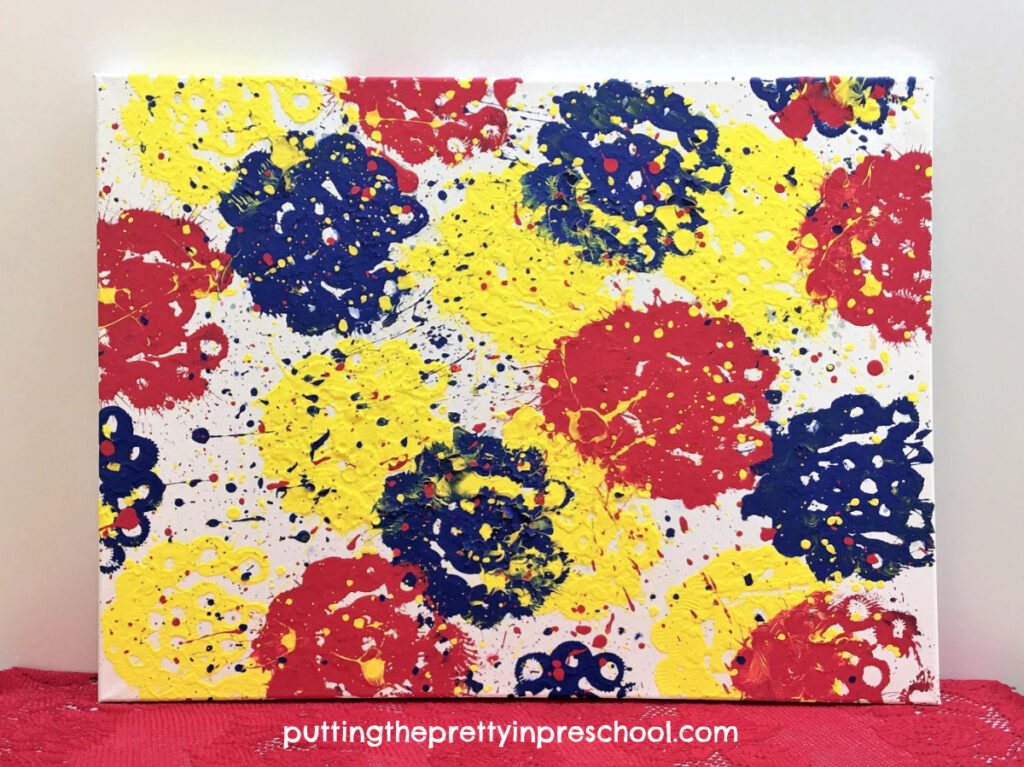 It's easy to fill a canvas with a bubble wand painting technique. Give this all-ages super fun art project. a try!
