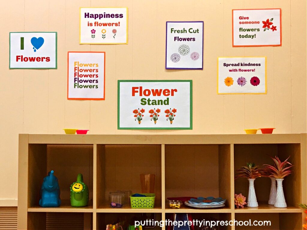 A fower-themed sign and quotes add a literacy component to a flower stand dramatic play center,