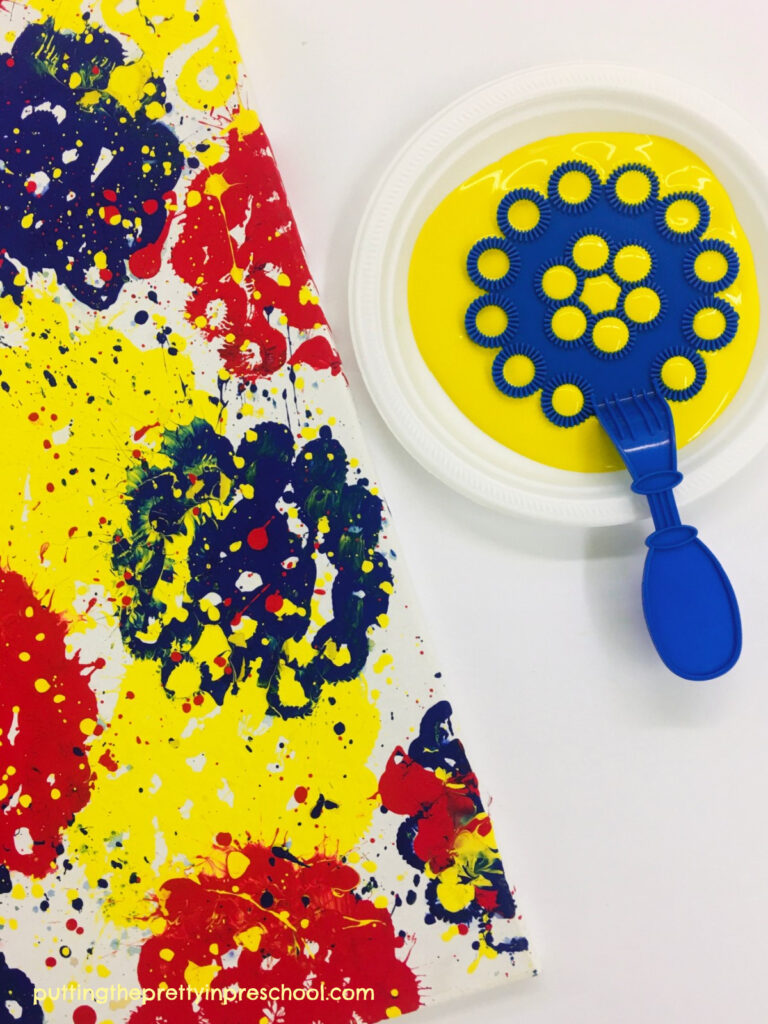 It's easy to fill a canvas with a bubble wand painting technique. Give this all-ages super fun art project a try!