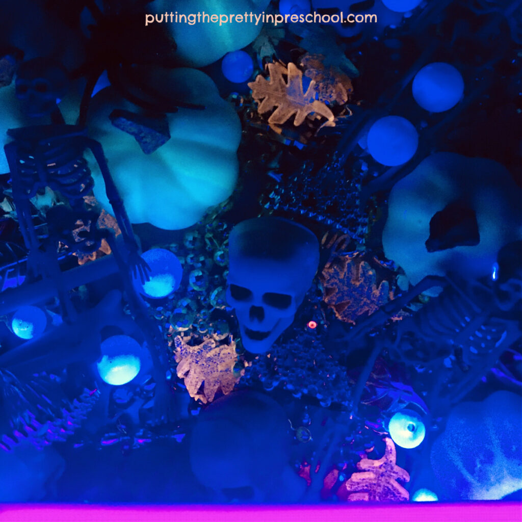 Find out what loose parts glow under a black light with this fun glam skeleton rice bin.