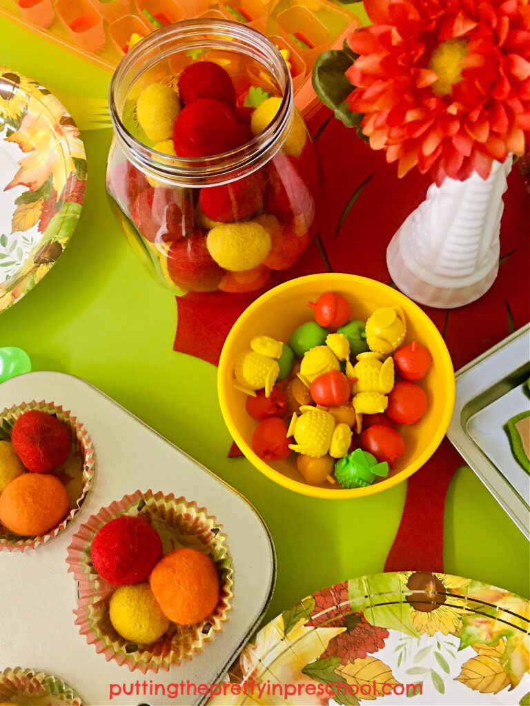 Loose parts such as game pieces and felt balls add imaginative possibilities to this easy-to-put-together fall tablescape pretend play setup.