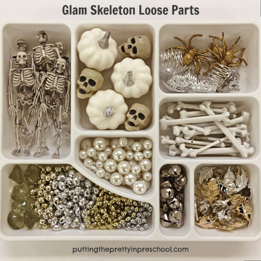 Skeleton-themed loose parts tray for early learners to explore. Gold and silver accessories add glamour to the tray.