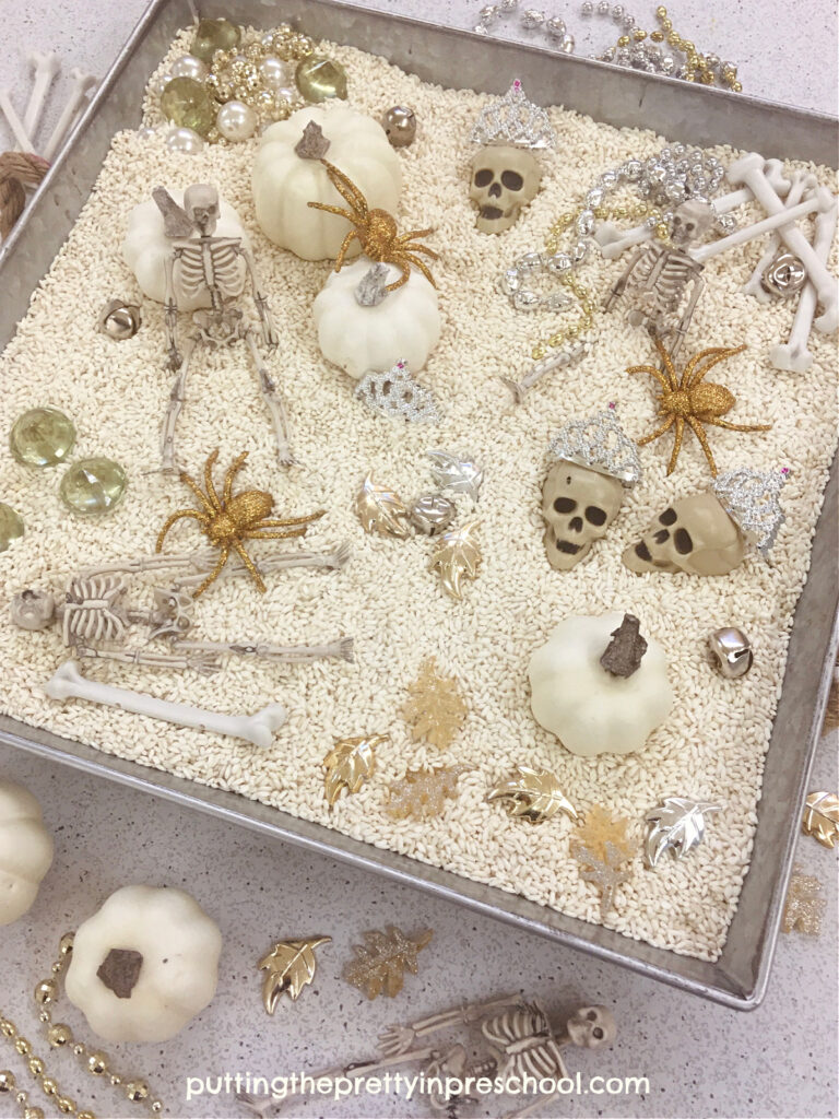 An oh-so-glam skeleton-themed rice bin featuring gold and silver loose parts. A non-threatening way for little learners to explore the skeleton.