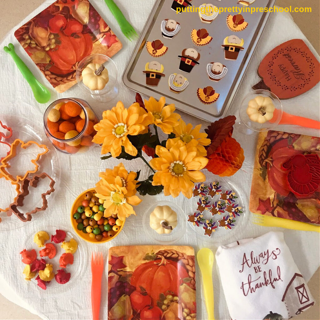 Turkey-themed loose parts are the highlight of this Thanksgiving tablescape pretend play setup.
